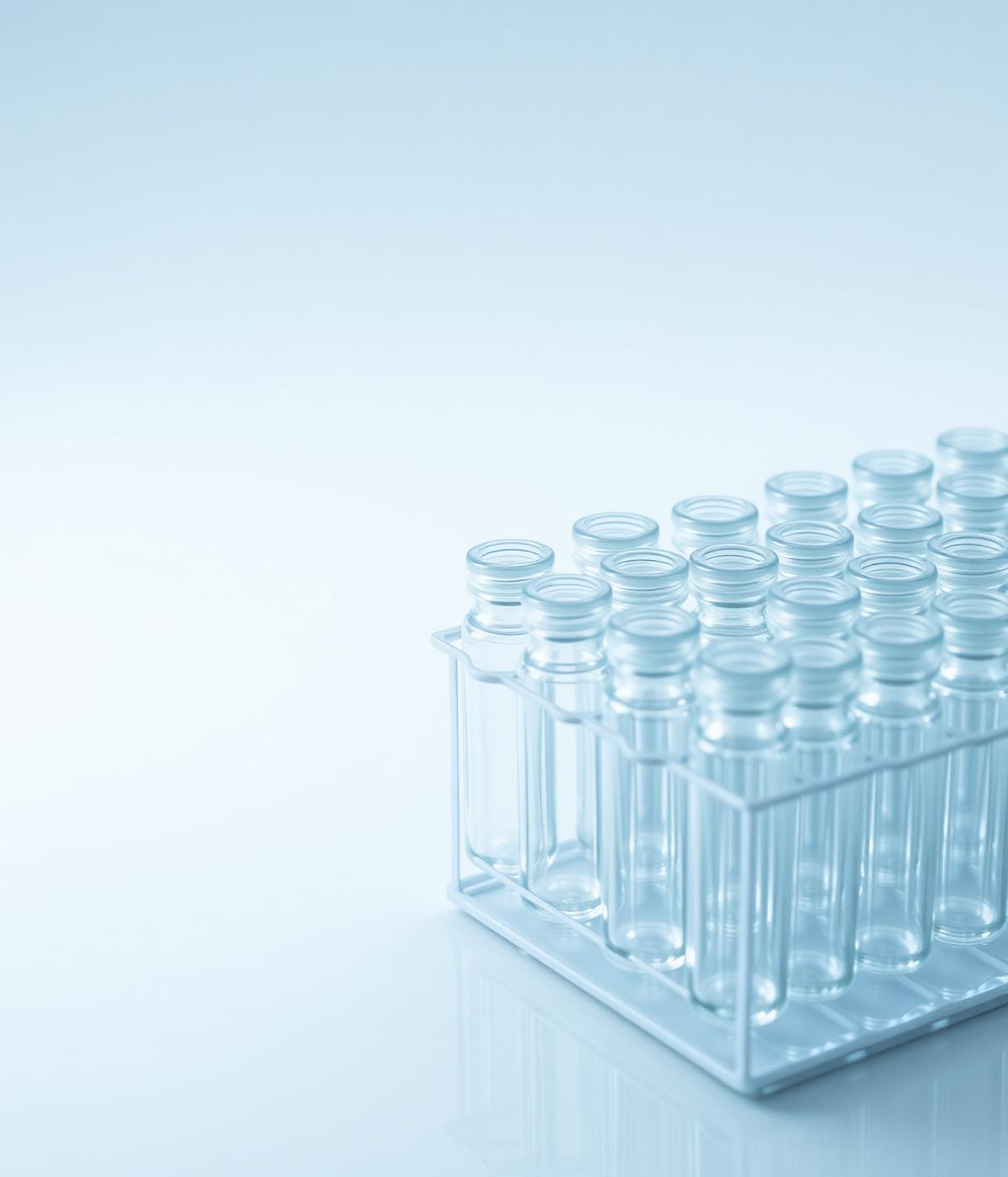 Kirkkaita injektiopulloja telineessä laboratoriossa